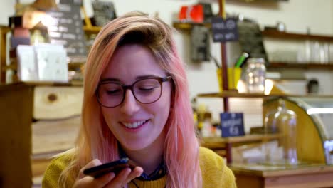 Young-woman-talking-on-the-phone-in-cafe-4k