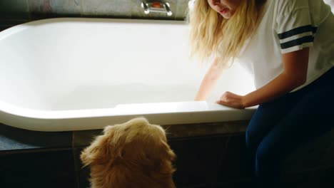 Woman-with-her-dog-sitting-on-bathtub-in-bathroom-4k