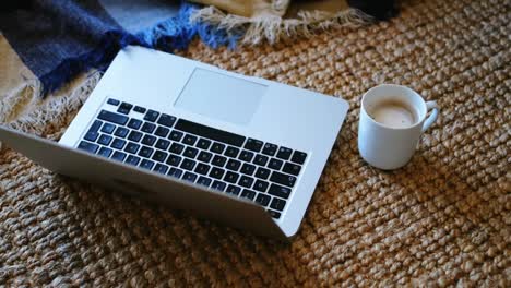 Laptop-Und-Kaffeetasse-Auf-Matte-Im-Wohnzimmer-4k