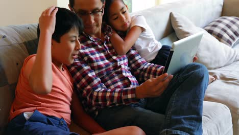 Vater-Und-Kinder-Nutzen-Digitales-Tablet-Im-Wohnzimmer-4k