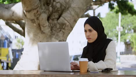 Attentive-woman-in-hijab-using-laptop-4k