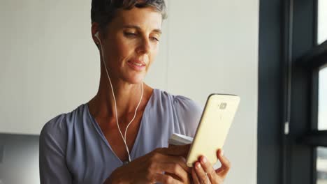 Mujer-De-Negocios-Tomando-Café-Mientras-Escucha-Música-En-El-Teléfono-Móvil-4k
