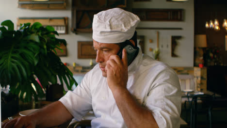 Male-chef-talking-on-mobile-phone-4k