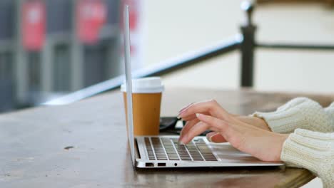 Woman-using-laptop-in-cafe-4k