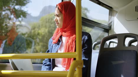 Frau-Im-Hijab-Schaut-Durch-Das-Fenster,-Während-Sie-Laptop-4K-Benutzt