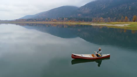 Man-rowing-boat-with-his-dog-on-a-lake-4k