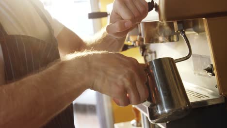 Male-waiter-using-coffeemaker-machine-in-cafe-4k