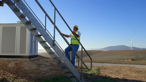 Male-engineer-walking-upstairs-in-the-wind-farm-4k
