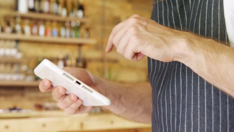 Male-waiter-using-digital-tablet-in-cafe-4k
