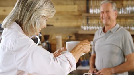 Senior-woman-having-coffee-at-cafe-counter-4k