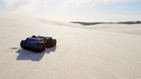 Binoculars-on-the-sand-in-desert-4k