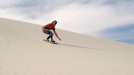 Man-sand-boarding-on-the-slope-in-desert-4k