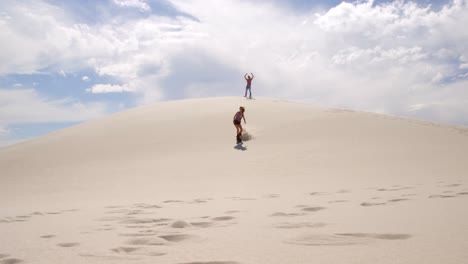 Paar-Beim-Sandboarden-In-Der-Wüste-4k