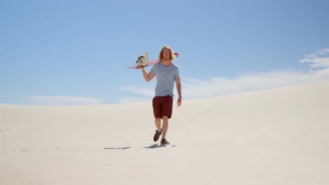 Man-with-sand-board-walking-in-the-desert-4k