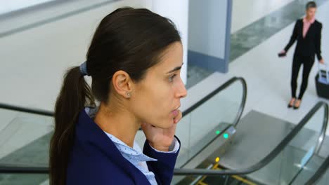 Businesswoman-talking-on-the-phone-while-on-elevator-4k-