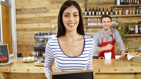 Woman-standing-with-open-sign-board-in-cafe-4k