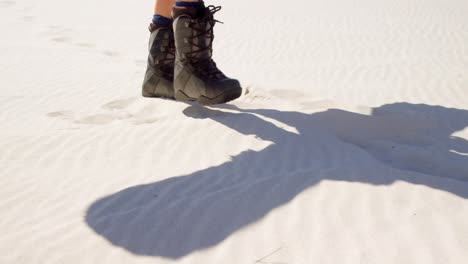 Woman-in-boots-walking-in-the-desert-on-a-sunny-day-4k