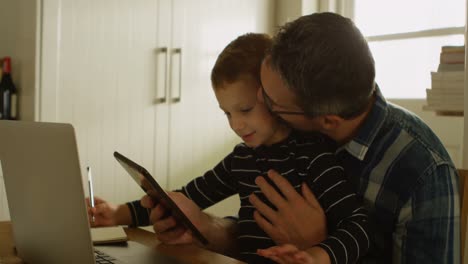 Padre-E-Hijo-Usando-Tableta-Digital-En-Casa-4k