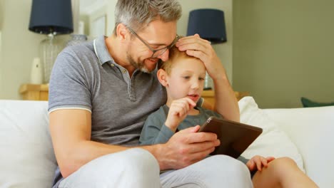 Vater-Und-Sohn-Nutzen-Digitales-Tablet-Auf-Dem-Sofa-4k