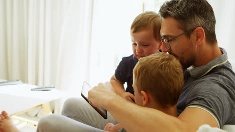 Vater-Und-Kinder-Nutzen-Digitales-Tablet-Auf-Dem-Sofa-4k