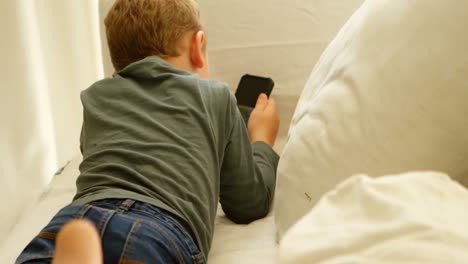 Boy-using-mobile-phone-on-sofa-4k