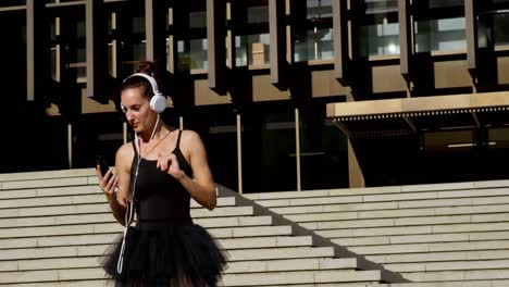 Female-ballet-dancer-listening-music-on-mobile-phone-4k