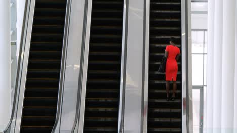 Businesswoman-using-mobile-phone-on-escalator-4k
