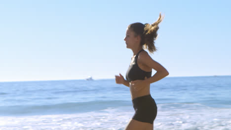 Mujer-En-Forma-Corriendo-En-La-Playa-4k