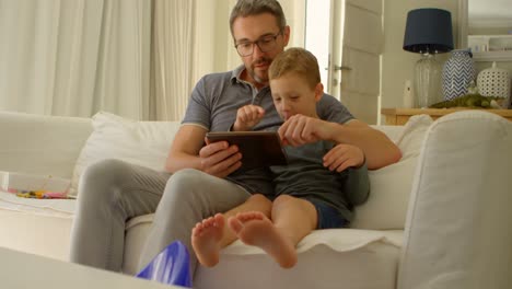 Vater-Und-Sohn-Nutzen-Digitales-Tablet-Auf-Dem-Sofa-4k