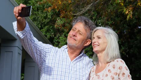 Senior-couple-taking-selfie-in-homeyard-4k