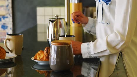 Woman-stirring-coffee-in-kitchen-4k