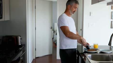 Man-preparing-breakfast-in-kitchen-4k