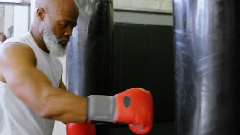 Senior-man-practicing-boxing-on-the-punching-bag-4k