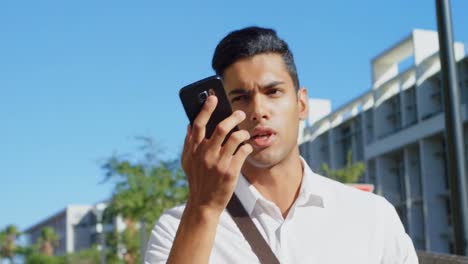 Man-talking-on-mobile-phone-while-walking-on-street-4k