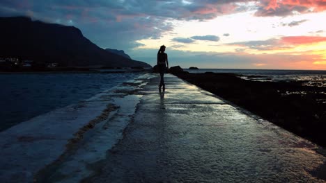 Woman-walking-on-promenade-at-beach-during-dusk-4k