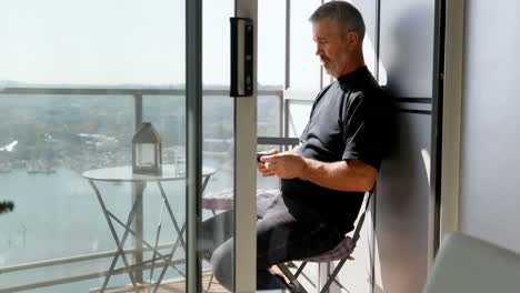 Man-using-mobile-phone-in-balcony-4k