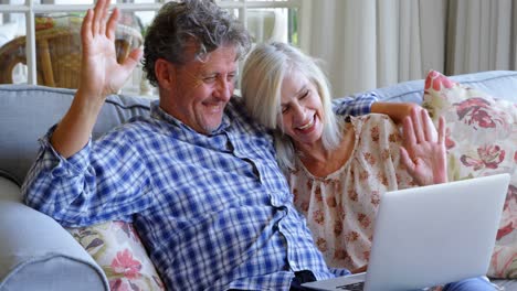 Senior-couple-making-video-call-on-laptop-on-sofa-4k