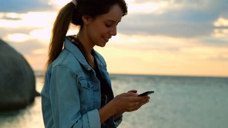 Woman-using-mobile-phone-at-beach-4k