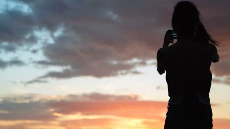 Frauen,-Die-Während-Des-Sonnenuntergangs-4K-Auf-Bilder-Am-Strand-Klicken