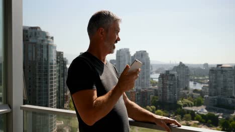 Man-talking-on-mobile-phone-in-balcony-4k