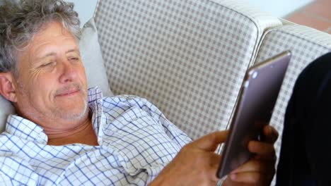 Älterer-Mann-Mit-Digitalem-Tablet-Liegt-Auf-Dem-Sofa-Auf-Der-Veranda-4k