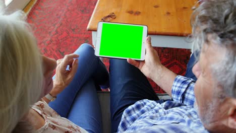 Senior-couple-using-digital-tablet-on-sofa-at-home-4k