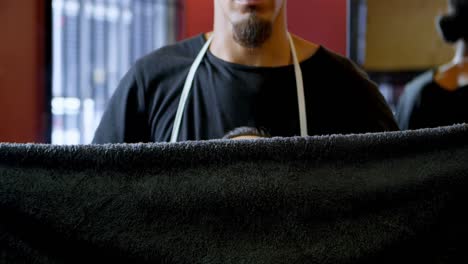 Barber-put-hot-towel-on-clients-face-4k