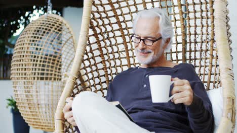 Senior-man-having-coffee-while-reading-a-book-4k