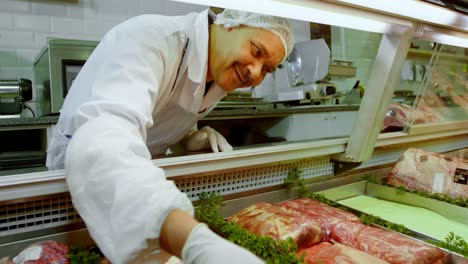 Butcher-arranging-meat-in-refrigerator-at-shop-4k