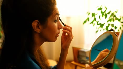 Female-video-blogger-applying-eyeshdow-in-front-of-mirror-4k