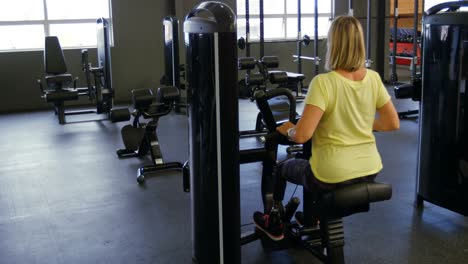 Ältere-Frau-Macht-Rückenübungen-An-Der-Maschine-Im-Fitnessstudio-4k