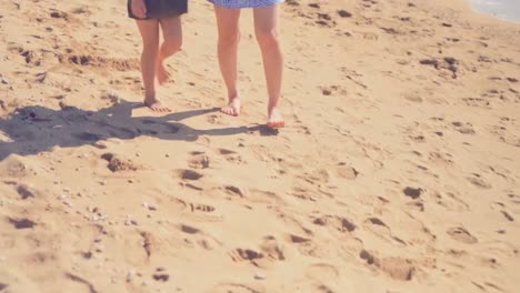 Mother-and-daughter-walking-on-the-beach-4k