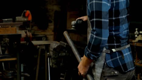 Blacksmith-using-grinder-machine-on-rod-4k