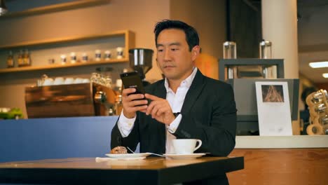Businessman-using-mobile-phone-in-cafe-4k